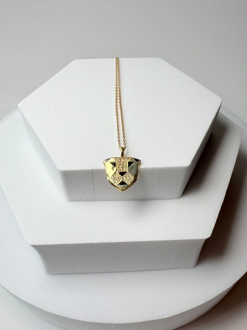 Geometric gold panther-head pendant with pavé diamonds and black enamel